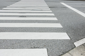 Fototapeta premium Zebra crosswalk on the road for safety when people walking cross the street, Pedestrian crossing, asphalt road, White lines and crosswalk on street background 