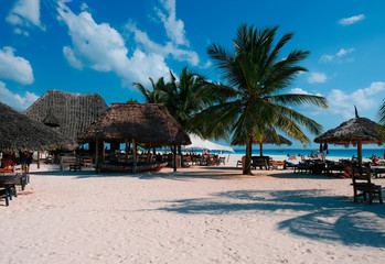 Beautiful view of the beach with white sand. People rest on the coast of the Indian Ocean. Zanzibar of Tanzania