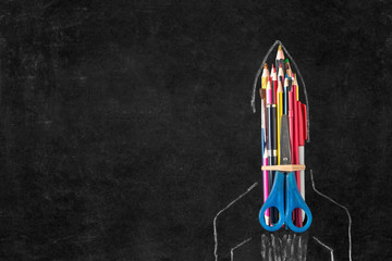 Back to school background. Rocket launch with school supplies on blackboard background with copy space.