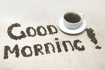Good morning! Coffee beans and coffee mug. Light background
