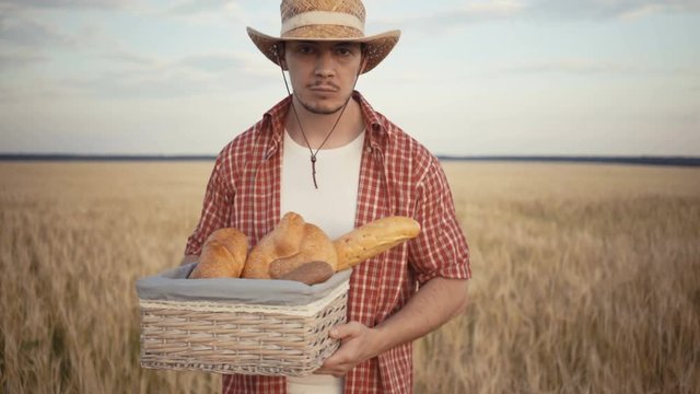 young farmer are stand along the wheat field with bread baskets