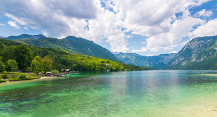 Bohinj Lake, Slovenia. Landscape of the lake with blue water and mountains in background. Slovenian alps and triglav mountain. Summer weather with clouds.