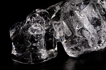 Ice on a black table. Melting piece of frozen water in a warm room.