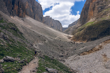 a man walks along a path in the Italian Alps