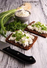 Cream Cheese on a slice of bread topped with fresh green onions