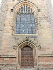 Fototapeta na wymiar Beautiful stained glass window and main entrance to Coleshill Parish Church St. Peter & St. Paul.