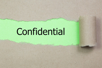 The word confidential appearing behind torn paper.