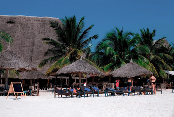Beautiful view of the beach with white sand. People rest on the coast of the Indian Ocean. Zanzibar of Tanzania