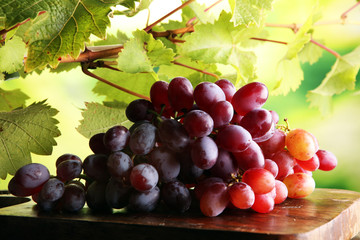 Grapes on wooden table and grape leaves . Healthy fresh fruit wine grapes.