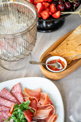 Food tray with delicious salami, pieces of sliced ham, sausage. Cutting sausage and cured meat on a celebratory table.