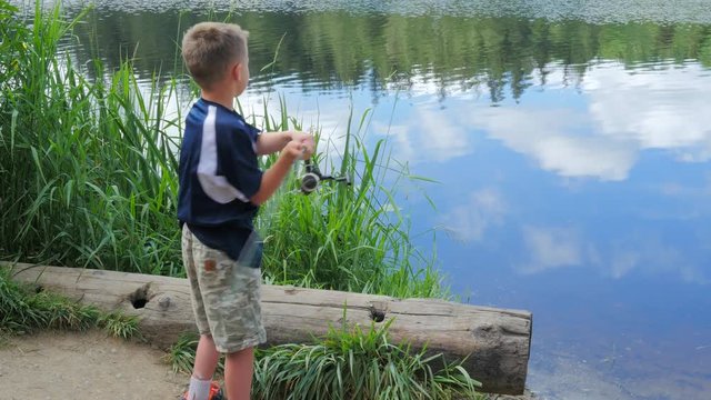 Young boy casting a fishing line into a lake.
