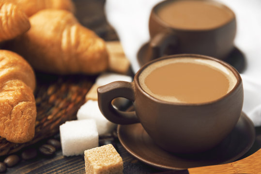 A cup of coffee on a blurry background of croissants