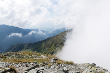mountain ridge covered by half with the cloud