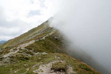mountain ridge covered by half with the cloud