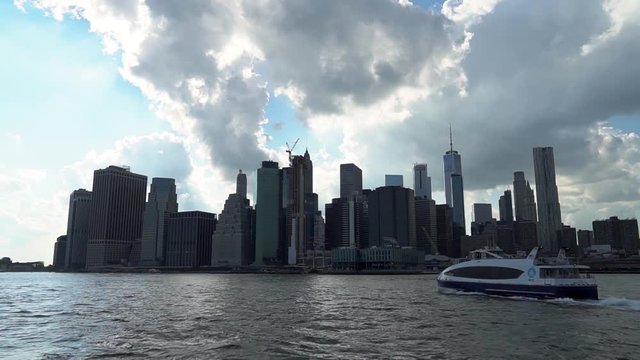 View of Lower Manhattan, NY from Brooklyn Bridge Park. Also a ferry crossing across the river.