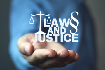 Man holding Law and Justice words with Scales and Paragraph symbol.
