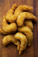 Fried shrimps tempura on rustic wooden board, closeup. From above, top view.