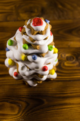 Gingerbread Christmas tree decorated with glaze on wooden table