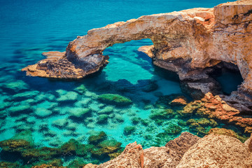 Beautiful natural rock arch near of Ayia Napa, Cavo Greco and Protaras on Cyprus island, Mediterranean Sea. Legendary bridge lovers. Amazing blue green sea and sunny day. Creative split toning