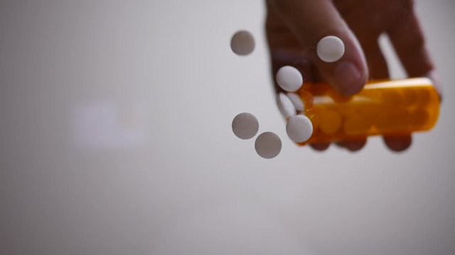 Pills Fall In Slow Motion Onto Glass Table