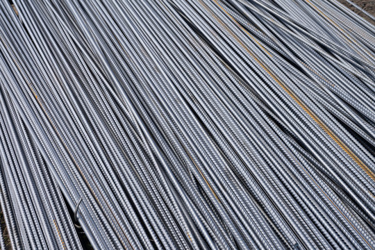 Stack of heavy metal reinforcement bars with periodic profile texture. Close up steel construction armature. Abstract industrial background concept. Copy space.