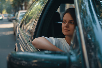 Young woman in casual wear Put Head Out of Window  while driving