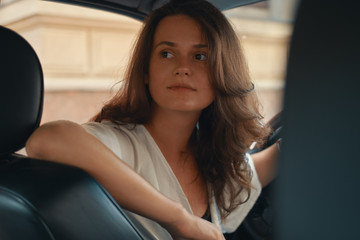 Fototapeta na wymiar Close-up portrait of woman holding hand on steering wheel