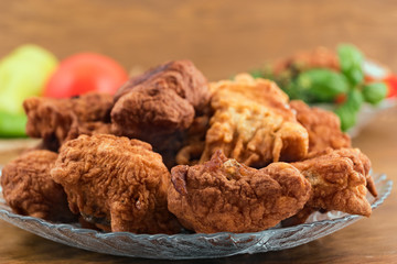 Fish dish of fried dough pieces with a golden  crust on a glass plate.