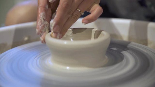 Close up of hands molding clay on pottery wheel