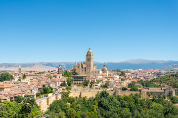 Naklejka premium Scenery of ancient town, old wall and cathedral of Segovia on hill during summer season with blue clear sky in Segovia, Spain