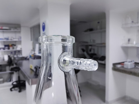 Buchner, vacuum, filter, suction, side-arm flask or Kitasato flask. Thick-walled Erlenmeyer glass flask with a short glass tube and protruding hose barb. Laboratory glassware for scientific research