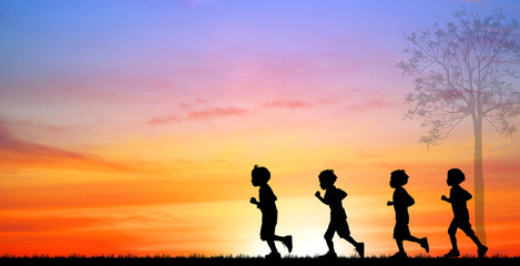 Fototapeta na wymiar Silhouette boys running on sunrise.