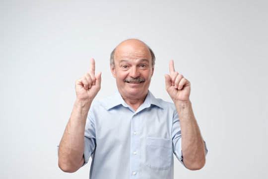 Smiling Senior Male Showing A New Idea Over White Background.