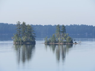 Reflection of islands on a calm lake in the morning 