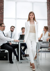 Obraz premium young business woman standing near desktop