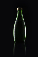 green soda bottle on the black