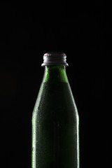 green soda bottle on the black