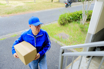 青色の作業服を着た宅配人