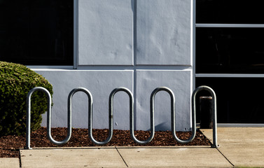 Curvy bike rack in front of a white wall