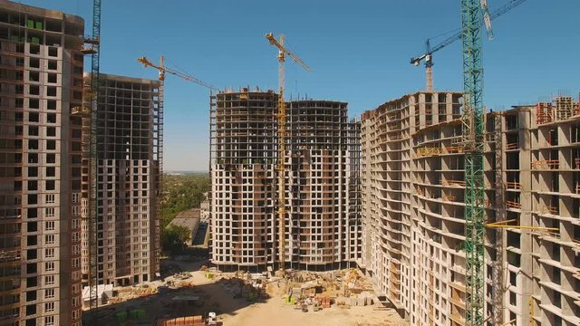 Construction of houses. Drone fly over construction site with tower cranes