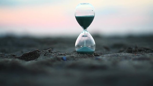 Sandy beach clock and falling blue feathers