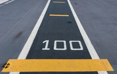 Number " 50 " on white and yellow runway. Takeoff runway and runway aircraft carrier on battleship. Public area.