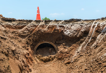 Concrete Drainage Pipe and orange traffic cone on a Construction Site .Concrete pipe stacked sewage...