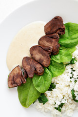 turkey hearts with rice and spinach served with gravy sauce
