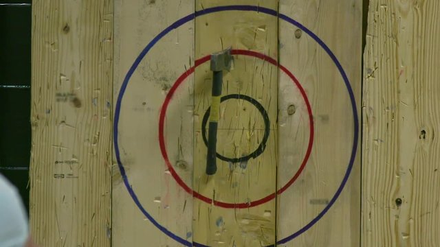 Man Throwing Axe And Hitting Wood Target In Slow Motion