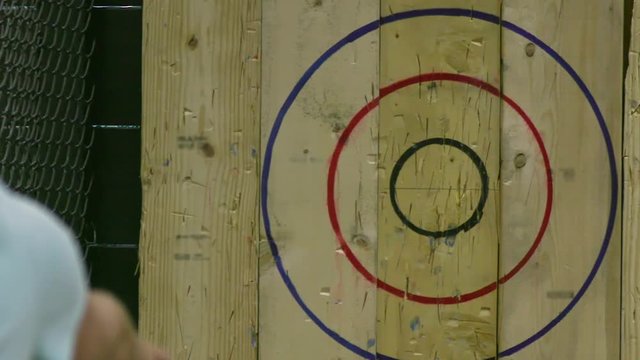 Man Throwing Axe and Hitting Wood Target in Slow Motion