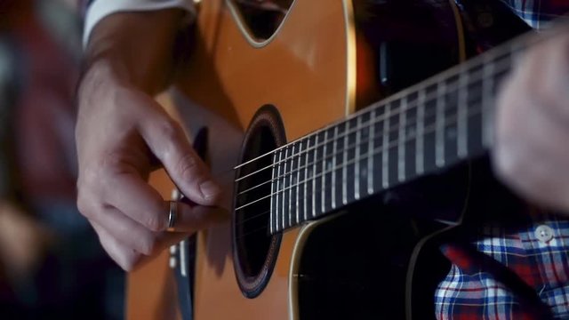 Closeup on the right hand of a guitarist playing arpeggios.