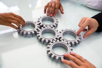 Business People's Hand Connecting Gears - obrazy, fototapety, plakaty