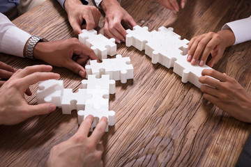 Businesspeople Solving Jigsaw Puzzle Together