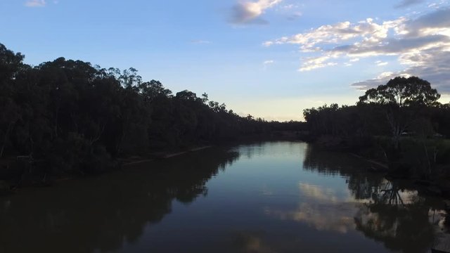Drone aerial pan left to right over the Murray River. Sky and clouds reflecting in river. Sunset. Cadell, New South Wales Australia. Sunset